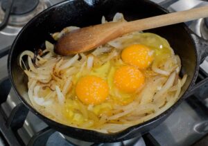 Cebolla con huevos en la sartén.