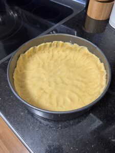 Masa de tarta cruda en molde de aro desmontable.